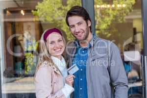 Smiling couple showing credit card