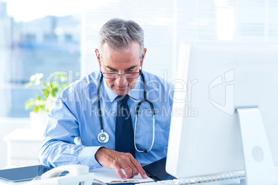 Male doctor examining document in hospital