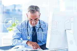 Male doctor examining document in hospital