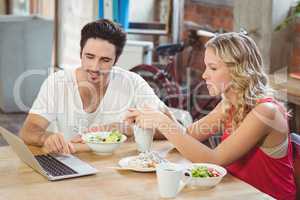 Man and woman discussing during coffee break in office