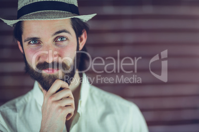 Portrait of confident man with hand on chin wearing hat