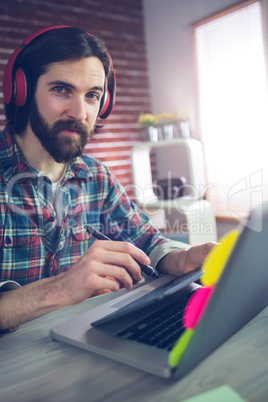 Portrait of confident businessman wearing headphones at office