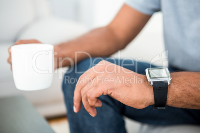 Close-up of man on coffee break with smart watch