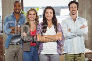 Portrait of happy business people with arms crossed in office