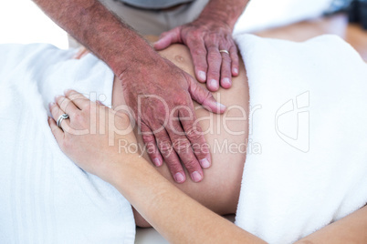 Cropped image of masseur massaging pregnant woman