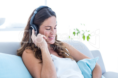 Happy pregnant woman listening music