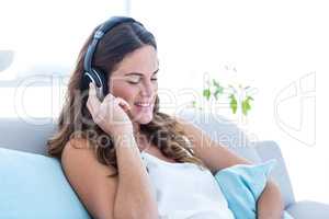 Happy pregnant woman listening music