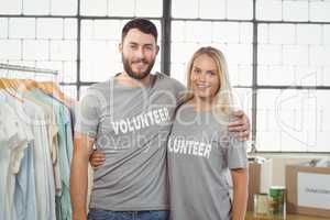 Portrait of joyful volunteers with arms around standing