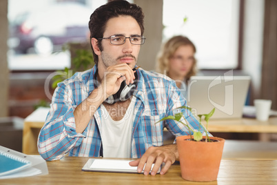 Thoughtful man with hand on chin sitting in office