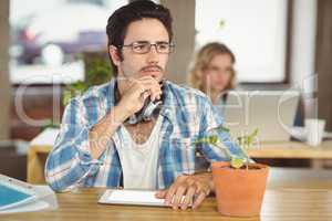 Thoughtful man with hand on chin sitting in office