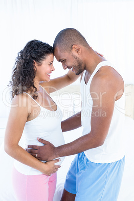 Happy pregnant wife with husband touching belly