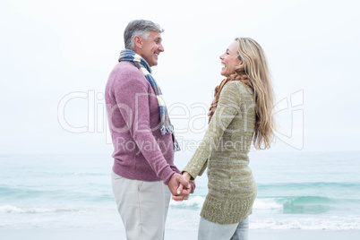 Happy couple standing holding each others hands