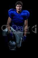 Portrait of confident American football player holding helmet wh