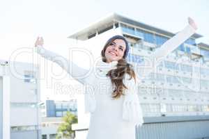 Pretty brunette with warm clothes raising hands