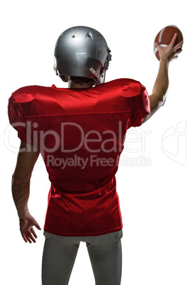 Rear view of sportsman in red jersey holding ball