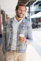 Young happy smiling man holding a a cup of coffee