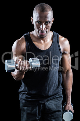 Portrait of muscular man exercising with dumbbell