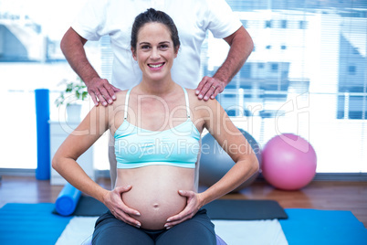 Portrait of pregnant woman touching her belly