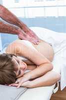 Male masseur massaging pregnant woman