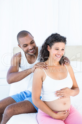 Husband massaging pregnant wife shoulders