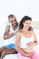 Husband massaging pregnant wife shoulders