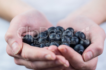 Woman showing handful of blueberries