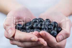 Woman showing handful of blueberries