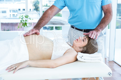 Pregnant woman getting reiki from male therapist