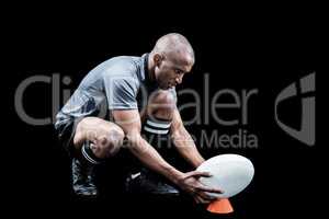 Rugby player keeping ball on kicking tee