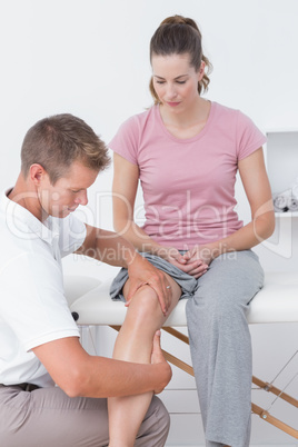 Doctor examining his patient knee