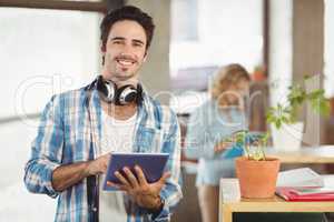 Portrait of happy businessman holding digital tablet creative of