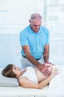 Male therapist massaging belly of pregnant woman