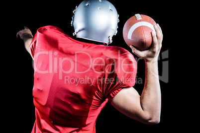 Rear view of American football player throwing ball