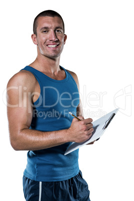 Portrait of confident sports coach writing on clipboard