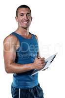 Portrait of confident sports coach writing on clipboard
