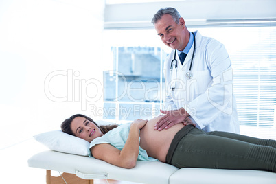 Portrait of doctor and pregnant woman in clinic