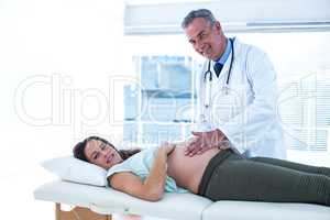 Portrait of doctor and pregnant woman in clinic