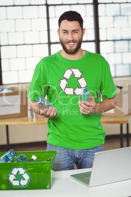 Portrait of man holding bottles in office