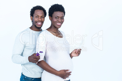 Portrait of happy husband holding paint roller while standing by