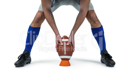 American football player placing ball between legs