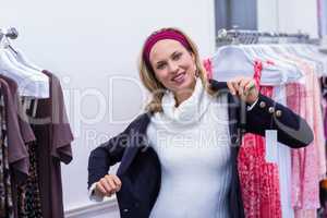 Smiling woman putting on blue coat