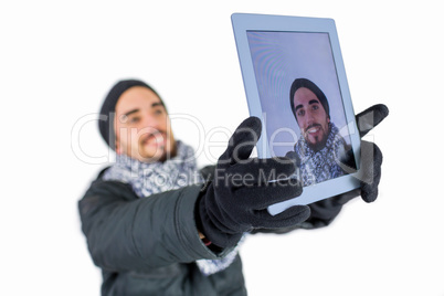 Bearded man using a tablet to take a selfie