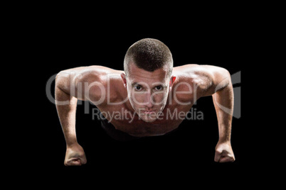 Portrait of confident shirtless man doing push ups