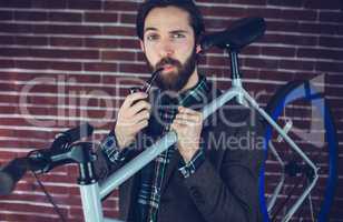 Portrait of smart man with bicycle smoking pipe