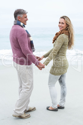 Happy couple standing holding each others hands