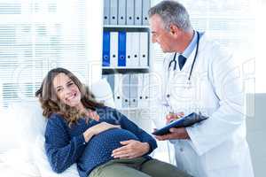 Doctor looking at pregnant woman in clinic