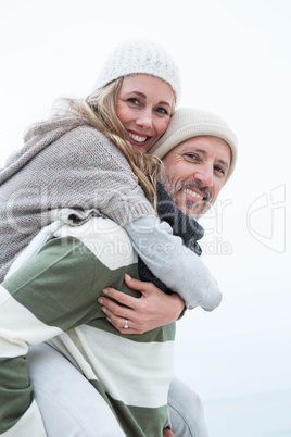 Smiling man giving his partner a piggy back