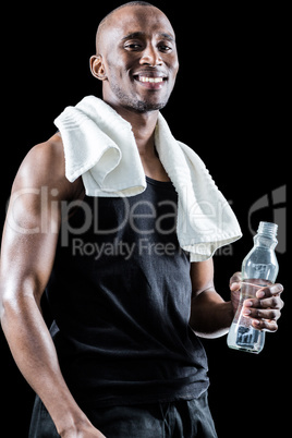 Portrait of happy muscular man with towel around neck holding bo