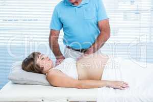 Male masseur massaging pregnant woman