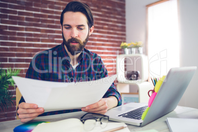 Confident creative businessman examining document